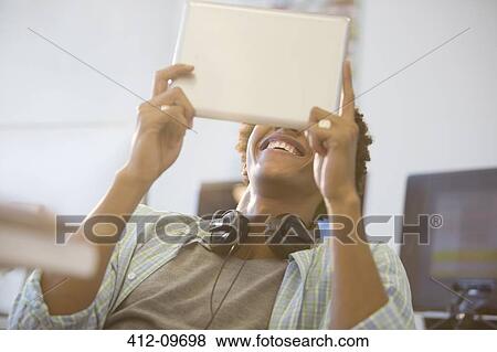 Businessman using digital tablet in office View Large Photo Image Stock Photo - Businessman using digital tablet in office. Fotosearch