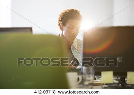 Stock Photo - Businessman working at desk in office. Fotosearch