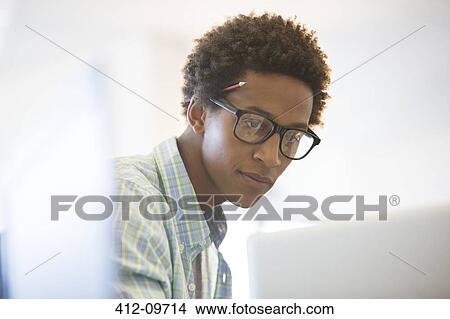 Picture - Businessman working at laptop in office. Fotosearch
