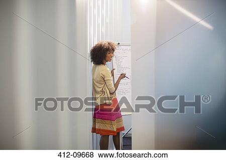 Stock Photo - Businesswoman at whiteboard in conference room. Fotosearch