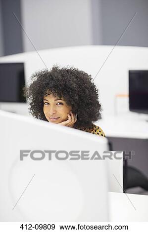 Businesswoman smiling at desk in office View Large Photo Image Stock Photo - Businesswoman smiling at desk in office. Fotosearch