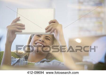Businesswoman using digital tablet in office View Large Photo Image Picture - Businesswoman using digital tablet in office. Fotosearch