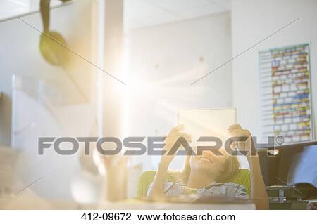 Businesswoman using digital tablet in office View Large Photo Image Stock Image - Businesswoman using digital tablet in office. Fotosearch