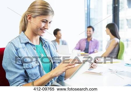 Stock Photography - Businesswoman using digital tablet in meeting. Fotosearch