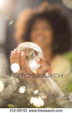 Stock Image - Close up of woman holding crystal ball. Fotosearch