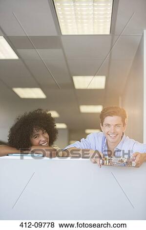 Stock Photo - Portrait of smiling business people holding circuit board in office. Fotosearch