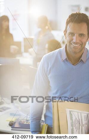 Stock Photo - Portrait of smiling businessman in office. Fotosearch