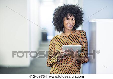 Picture - Portrait of woman using digital tablet in office. Fotosearch