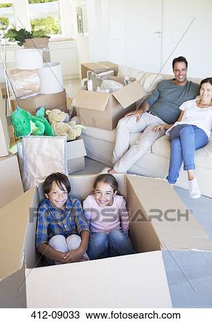 Brother and sister inside cardboard box in living room View Large Photo Image Stock Image - Brother and sister inside cardboard box in living room. Fotosearch