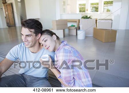 Stock Image - Couple drinking coffee in new house. Fotosearch