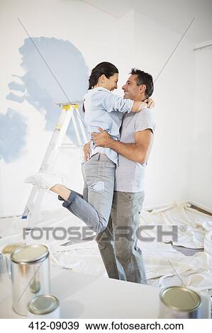 Couple hugging among paint supplies View Large Photo Image Stock Photo - Couple hugging among paint supplies. Fotosearch