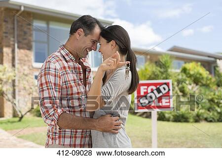 Couple hugging outside new house View Large Photo Image Stock Photo - Couple hugging outside new house. Fotosearch