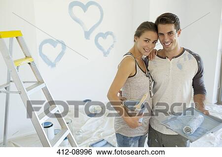 Couple painting blue hearts on wall View Large Photo Image Stock Photograph - Couple painting blue hearts on wall. Fotosearch