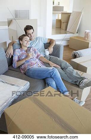 Couple relaxing with coffee on sofa in new house View Large Photo Image Stock Photography - Couple relaxing with coffee on sofa in new house. Fotosearch