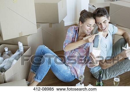 Couple sharing Chinese take out food in new house View Large Photo Image Stock Photography - Couple sharing Chinese take out food in new house. Fotosearch
