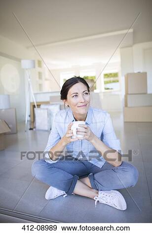 Happy woman enjoying coffee among cardboard boxes View Large Photo Image Stock Photo - Happy woman enjoying coffee among cardboard boxes. Fotosearch