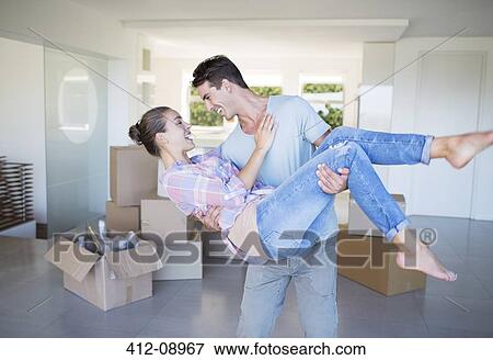 Man carrying girlfriend in new house View Large Photo Image Stock Photo - Man carrying girlfriend in new house. Fotosearch