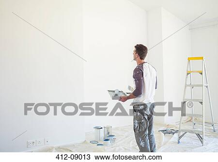 Man with paint tray looking up at white wall View Large Photo Image Stock Image - Man with paint tray looking up at white wall. Fotosearch