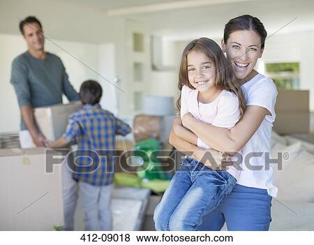 Stock Photo - Mother and daughter hugging in new house. Fotosearch