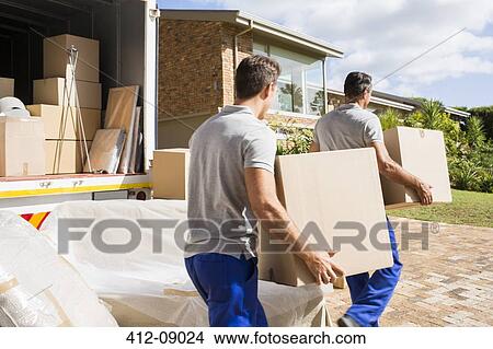 Movers carrying boxes in new house View Large Photo Image Picture - Movers carrying boxes in new house. Fotosearch