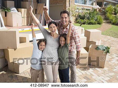 Stock Photo - Portrait of family cheering near moving van in driveway. Fotosearch