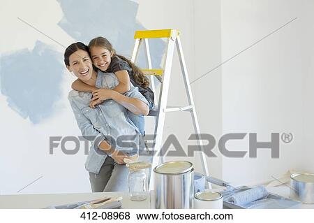 Portrait of mother and daughter hugging near paint supplies View Large Photo Image Stock Photo - Portrait of mother and daughter hugging near paint supplies. Fotosearch