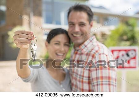 Portrait of smiling couple holding house keys View Large Photo Image Stock Photography - Portrait of smiling couple holding house keys. Fotosearch