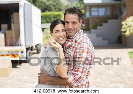 Stock Photo - Portrait of smiling couple in front of new house. Fotosearch
