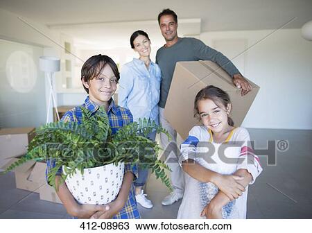 Portrait of smiling family holding belongings in new house View Large Photo Image Stock Image - Portrait of smiling family holding belongings in new house. Fotosearch