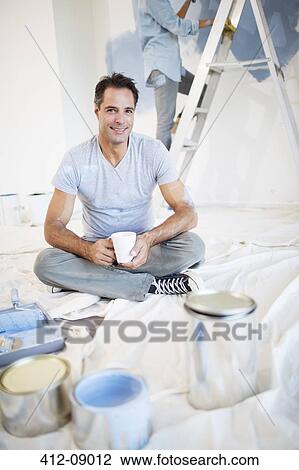 Portrait of smiling man drinking coffee among painting supplies View Large Photo Image Stock Image - Portrait of smiling man drinking coffee among painting supplies. Fotosearch