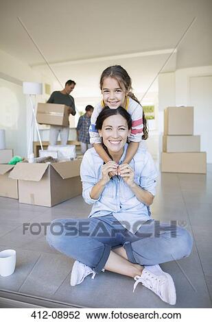 Portrait of smiling mother and daughter among cardboard boxes View Large Photo Image Stock Image - Portrait of smiling mother and daughter among cardboard boxes. Fotosearch