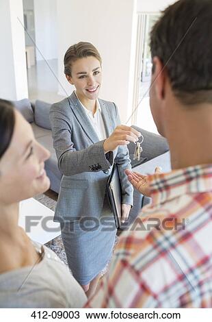 Realtor giving couple house keys View Large Photo Image Stock Image - Realtor giving couple house keys. Fotosearch