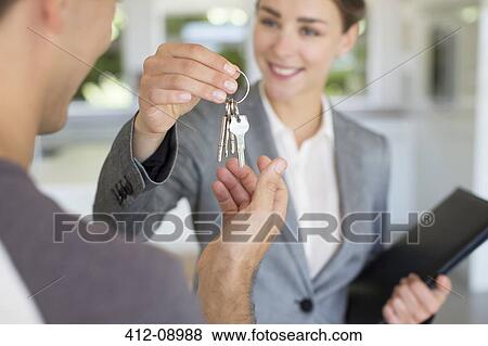 Realtor giving man house keys View Large Photo Image Stock Photo - Realtor giving man house keys. Fotosearch