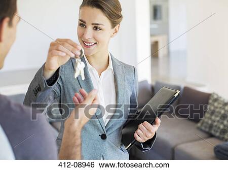 Stock Photograph - Realtor giving man keys to new house. Fotosearch