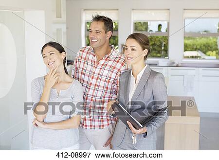 Realtor showing couple house View Large Photo Image Stock Photo - Realtor showing couple house. Fotosearch