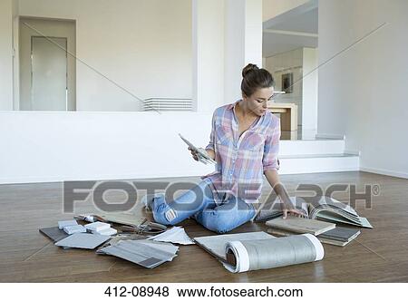 Woman viewing carpet and tile swatches on floor in new house View Large Photo Image Stock Photo - Woman viewing carpet and tile swatches on floor in new house. Fotosearch