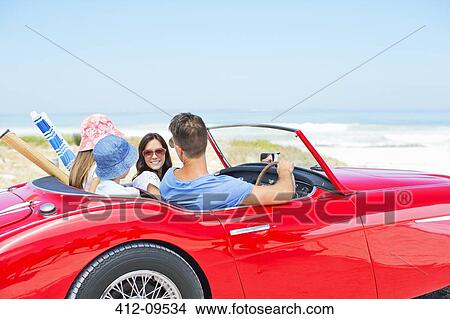 Picture - Family driving convertible to beach. Fotosearch