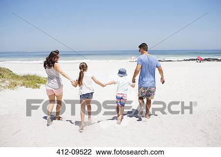 Family holding hands and walking on beach View Large Photo Image Stock Image - Family holding hands and walking on beach. Fotosearch