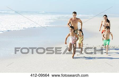 Picture - Family running on beach. Fotosearch