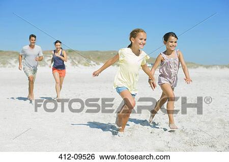 Family running together on beach View Large Photo Image Stock Photograph - Family running together on beach. Fotosearch