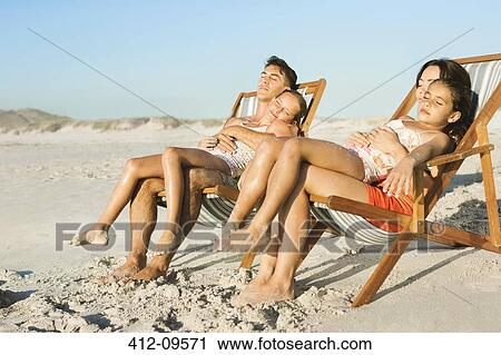 Family sleeping in lounge chairs on beach View Large Photo Image Stock Image - Family sleeping in lounge chairs on beach. Fotosearch