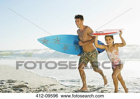 Father and daughter carrying surfboard and bodyboard on beach View Large Photo Image Stock Photograph - Father and daughter carrying surfboard and bodyboard on beach. Fotosearch