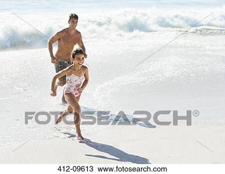 Father and daughter running in surf at beach View Large Photo Image Stock Image - Father and daughter running in surf at beach. Fotosearch