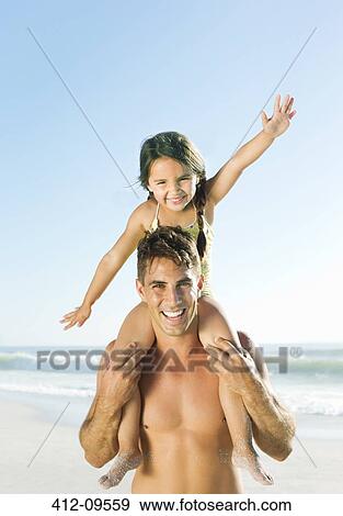 Father carrying daughter on shoulders at beach View Large Photo Image Stock Photo - Father carrying daughter on shoulders at beach. Fotosearch