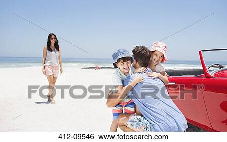 Father hugging daughter and son near convertible at beach View Large Photo Image Stock Photograph - Father hugging daughter and son near convertible at beach. Fotosearch