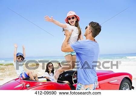 Father lifting daughter from convertible at beach View Large Photo Image Stock Image - Father lifting daughter from convertible at beach. Fotosearch