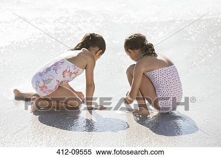 Girls playing together in surf on beach View Large Photo Image Stock Photography - Girls playing together in surf on beach. Fotosearch