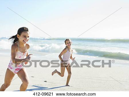 Stock Image - Girls running on beach. Fotosearch
