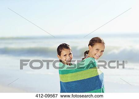 Girls wrapped in towel on beach View Large Photo Image Stock Photo - Girls wrapped in towel on beach. Fotosearch