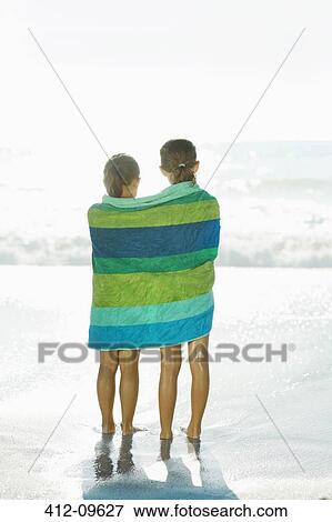 Girls wrapped in towel on beach View Large Photo Image Stock Photo - Girls wrapped in towel on beach. Fotosearch